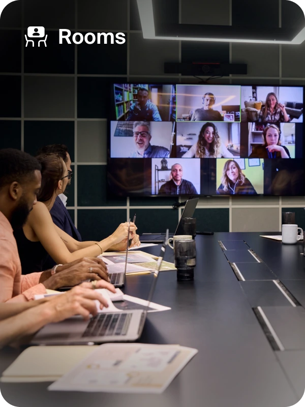 Attendees in a Zoom conference room engaged in discussion, with a large screen showing visual content.